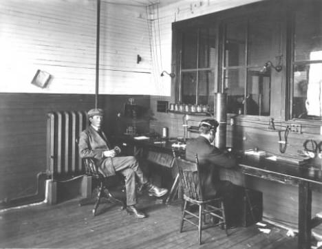 Operator James Holmes receives messages at Marconi Towers from Clifden, Ireland in 1907, while Marconi looks on